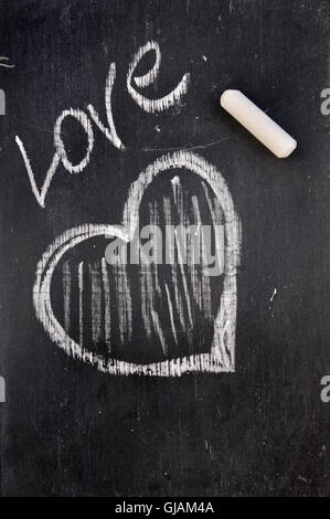 Il simbolo del cuore sulla lavagna. Cuore bianco gesso disegno su una  lavagna di scuola con posto per il testo. Amore romantico San Valentino  vacanze concetto. Copia Foto stock - Alamy