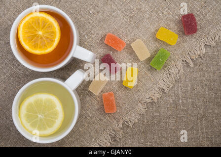 Tazze di tè diversi e gelatine sul sacco Foto Stock