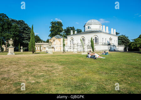 Amici rilassarsi nel parco di Chiswick House, una villa palladiana dei primi anni 18th a Chiswick, Londra, Inghilterra, Regno Unito Foto Stock