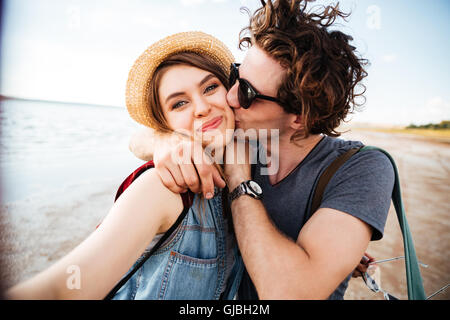 Felice coppia giovane baciare e tenendo selfie all'aperto Foto Stock