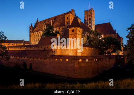 Castello di Malbork da notte in Polonia, fortezza medievale costruita dai Cavalieri Teutonici, il più grande castello di mattoni nel mondo. Foto Stock