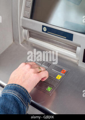 Primo piano della donna di mano immettendo il codice PIN su ATM tastiera macchina Foto Stock