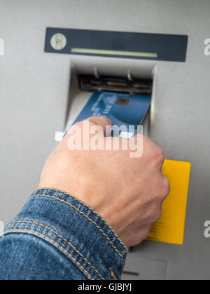 Primo piano della donna di mano inserire e-card nello slot ATM Foto Stock