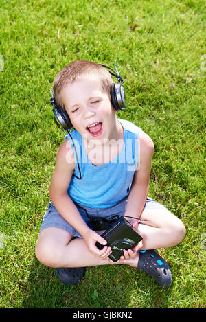 Little Boy con il vecchio lettore di cassette audio e cuffie Foto Stock