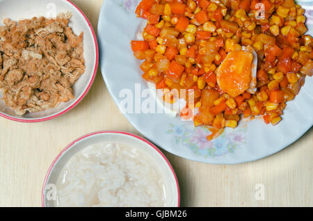 Riso bollito o polenta o farinata o porridge con secchi cotti Shredded carne di maiale (o di maiale floss) e salati uovo mescolato con verdure su Foto Stock