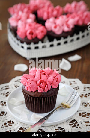 Tortine. Tortini di cioccolato con rosa crema di burro alla vaniglia rosebuds Foto Stock