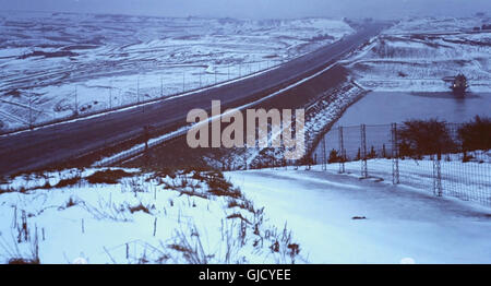 Cielo grigio neve vista da B6114 Saddleworth Road verso la M62, chiuso dall'azione industriale (una mancanza di gritting) in inverno di malcontento 1978-79, attraversando Scammonden Dam, nella sua traversata del Sud Pennines, West Yorkshire, Regno Unito Foto Stock