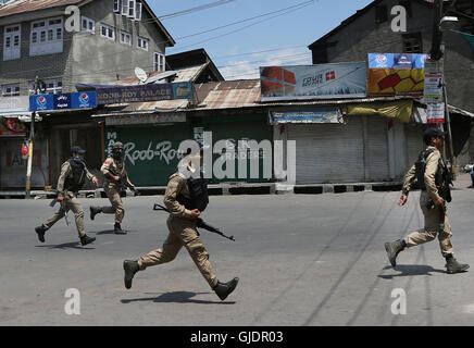 Srinagar, Indiano-controllato del Kashmir. Il 15 agosto, 2016. Poliziotti indiano rush per prendere posizione in prossimità del sito di un gunfight in Srinagar, capitale di Indiano-Kashmir controllata, 15 agosto 2016. Almeno sette Indian personale delle forze di sicurezza sono rimasti feriti in un attentato a indiano-controllato del Kashmir capitale Srinagar, un ufficiale di polizia detto lunedì. Credito: Javed Dar/Xinhua/Alamy Live News Foto Stock