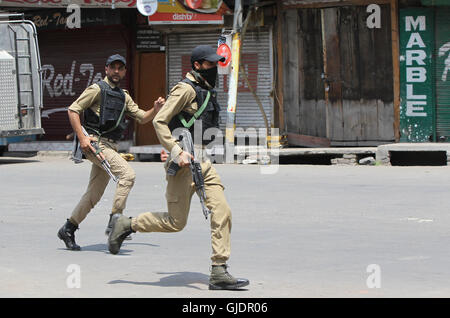 Srinagar, Indiano-controllato del Kashmir. Il 15 agosto, 2016. Poliziotti indiano rush per prendere posizione in prossimità del sito di un gunfight in Srinagar, capitale di Indiano-Kashmir controllata, 15 agosto 2016. Almeno sette Indian personale delle forze di sicurezza sono rimasti feriti in un attentato a indiano-controllato del Kashmir capitale Srinagar, un ufficiale di polizia detto lunedì. Credito: Javed Dar/Xinhua/Alamy Live News Foto Stock