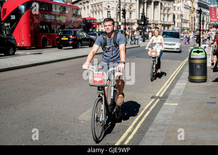Londra, Regno Unito. Il 12 agosto 2016. I turisti di marcia popolare Santander noleggiare biciclette in Piccadilly. Foto Stock