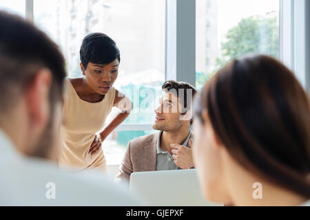Felici i giovani imprenditori a riunione in ufficio Foto Stock