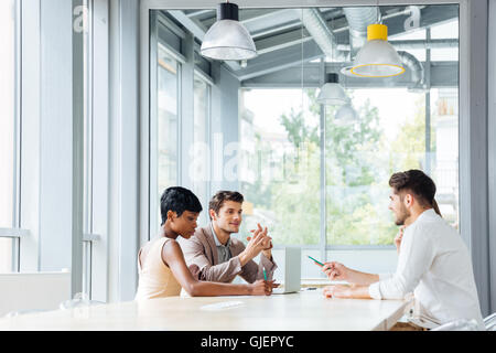 Un gruppo di giovani imprenditori e di lavoro il brainstorming sulla riunione in ufficio Foto Stock