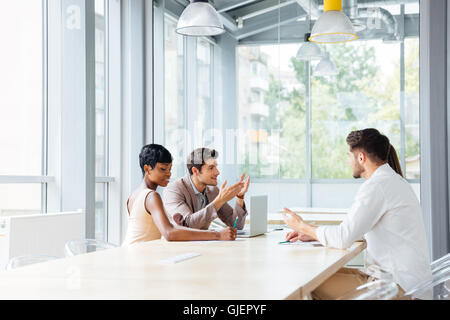 Un gruppo di giovani imprenditori che lavorano in ufficio e per discutere di nuove idee Foto Stock