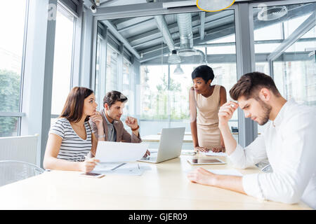 Gruppo di felice fiducioso giovane gente di affari in una riunione con il team leader Foto Stock