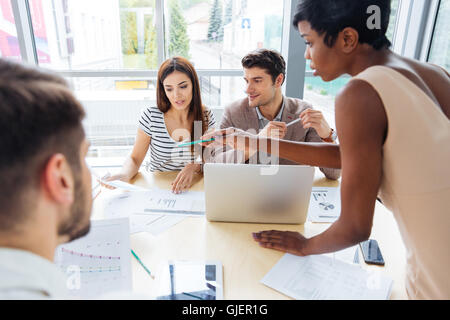 Gruppo multietnico di giovani uomini di affari che la preparazione per la presentazione insieme in ufficio Foto Stock