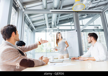 Allegro piuttosto giovane donna fare presentazione con lavagna a fogli mobili in office Foto Stock