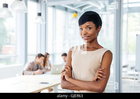 Il successo americano africano giovane imprenditrice in piedi con le mani giunte in office Foto Stock