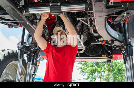 Auto meccanico che lavora al di sotto di un sollevato Foto Stock