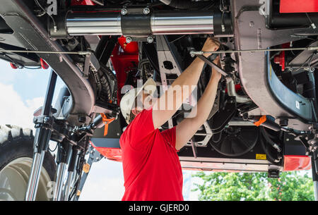 Auto meccanico che lavora al di sotto di un sollevato Foto Stock