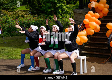 Un gruppo di ragazze di eseguire la routine di danza vestito in kit calcio in Buxton Peak District DERBYSHIRE REGNO UNITO Foto Stock