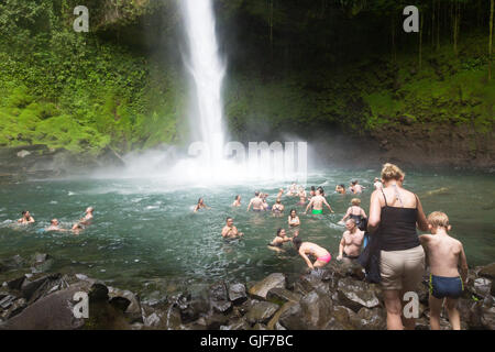 I turisti il nuoto in la Fortuna cascata, La Fortuna, provincia di Arenal, Costa Rica, America Centrale Foto Stock