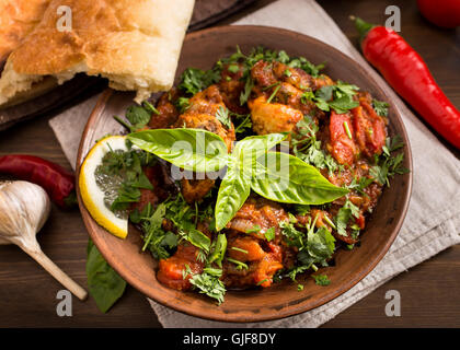 Stufato di pollo con pomodori e le erbe aromatiche Foto Stock