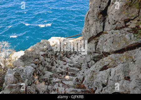 Scale scavate e costruite nella roccia che porta direttamente al mare, Sicilia, Italia Foto Stock