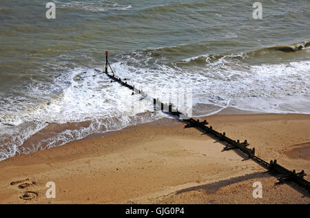 Una vista di un vecchio stile frangiflutti in legno sulla spiaggia ovest dalla scogliera a Mundesley, Norfolk, Inghilterra, Regno Unito. Foto Stock