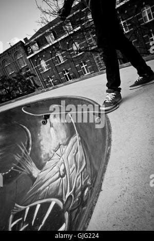 Un guidatore di skateboard si prepara a scendere in a Bruxelles skate park, Belgio Foto Stock