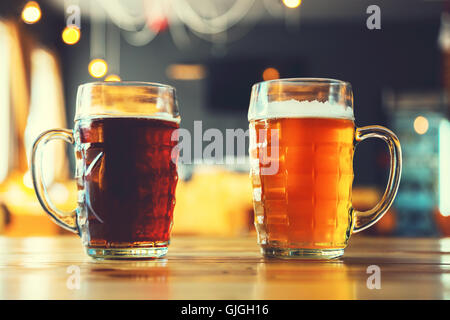 Coppe di luce e di birra scura su una tavola di legno su un pub sfondo. un assortimento di alcool in un volo pronto per la degustazione Foto Stock