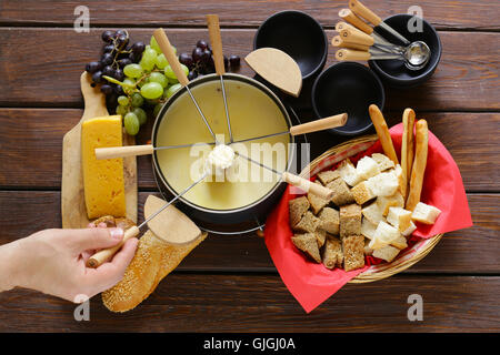 Tradizionale set di utensili per la fonduta, con pane, formaggio e uva Foto Stock