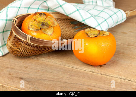 Persimmon colore giallo frutti maturi sulla tavola di legno Foto Stock