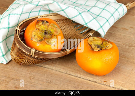 Persimmon colore giallo frutti maturi sulla tavola di legno Foto Stock