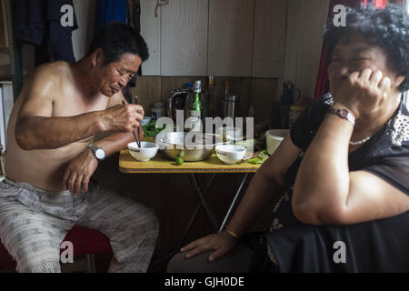 Hunchun, provincia di Jilin, Cina. 1 agosto, 2016. Il sig. Xie (sinistra) e sua moglie a mangiare il pranzo dopo la pesca nel Fiume Tumen. Un piccolo villaggio di pescatori dove si trova nel villaggio di Fangchuan, vicino Hunchun. Intorno 20 fishmen live qui facendo una da vivere con la pesca nel Fiume Tumen. La Cina e la Corea del Nord dispone di circa 1.420 km di confine, Il Yalu e Tumen fiumi, come il naturale linea di confine, separate i due paesi. La Cina e la Corea del Nord sono stati ancora una volta il famoso come intimo come 'le labbra e i denti''. Come Kim Jong Onu essendo il Supremo della Repubblica Popolare Democratica di Corea e la non chiara le bombe sono state testate e hanno il loro re Foto Stock