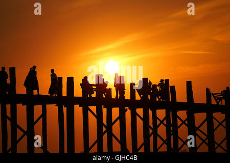 Silhouette di persone che camminano attraverso il ponte U Bein, Mandalay, Myanmar Foto Stock