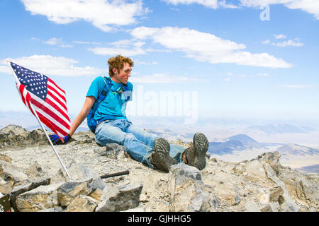 Ragazzo adolescente seduto sul vertice di montagna, Borah Peak, Idaho, America, STATI UNITI D'AMERICA Foto Stock