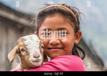 Il Nepal, ragazza con capra nel villaggio di montagna. Foto Stock