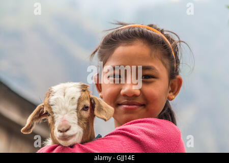 Il Nepal, ragazza con capra nel villaggio di montagna. Foto Stock