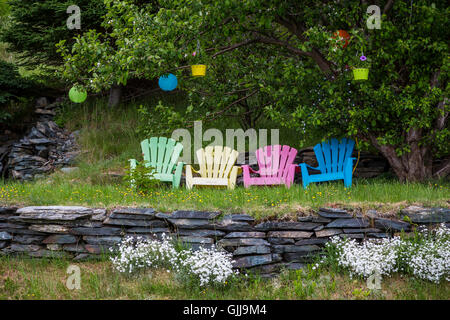 Un giardino con colorate sedie Adirondack vicino a Bay Roberts, Terranova e Labrador, Canada. Foto Stock