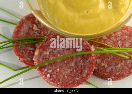 Salame-affettato e senape in recipiente di vetro Foto Stock