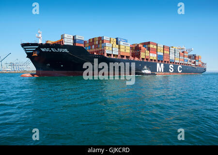 Rimorchiatore AMNAV guidare la Mediterranean Shipping Company di portacontainer, MSC Elodie, al suo posto di ormeggio nel porto di Long Beach, California, Stati Uniti d'America. Foto Stock