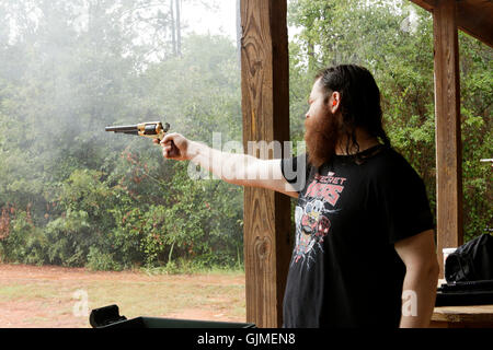 L uomo riprese di polvere nera pistola a campo esterno. Foto Stock