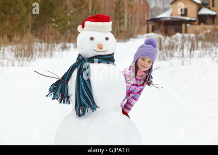 Kid giocando con il pupazzo di neve Foto Stock