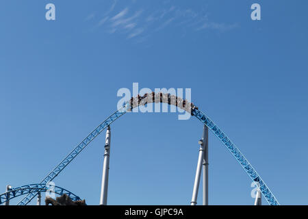 Blue roller coaster loop con il carrello nella parte anteriore del cielo blu Foto Stock