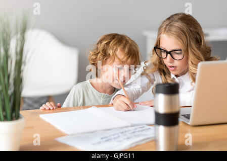 Ragazza insegnando il suo fratello più piccolo Foto Stock