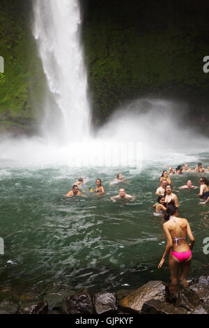 I turisti il nuoto in la Fortuna cascata, La Fortuna, provincia di Arenal, Costa Rica, America Centrale Foto Stock