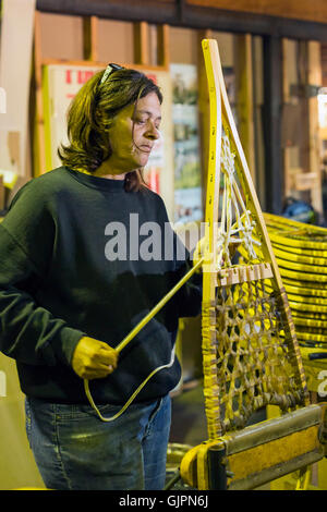 Shingleton, Michigan - Julie Holmes stringhe di racchette da neve al Iverson fabbrica con racchette da neve. Foto Stock