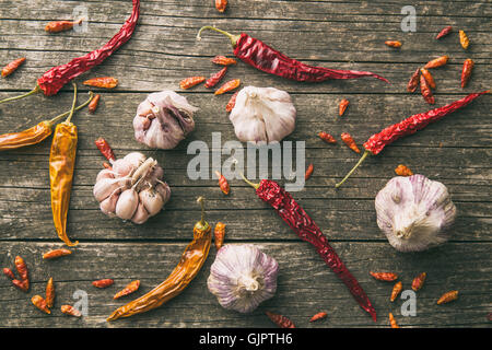 Aglio e Peperoncino sul vecchio tavolo in legno. Vista dall'alto. Foto Stock