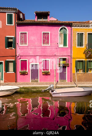 Case con terrazza in riva al mare dipinte con colori vivaci sull'isola di Burano. Venezia, Italia. Foto Stock