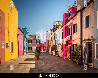 Tradizionali case terrazzate dipinte di colore con lavanderia appesa all'esterno su linee di lavaggio, sull'isola di Burano. Italia Foto Stock